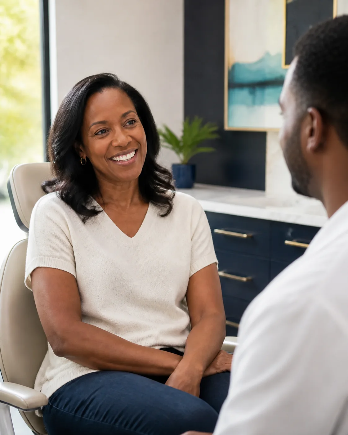 A patient smiling while speaking with a dentist